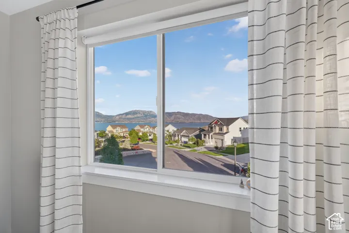 Expansive window offering a broad landscape with a body of water and distant mountains