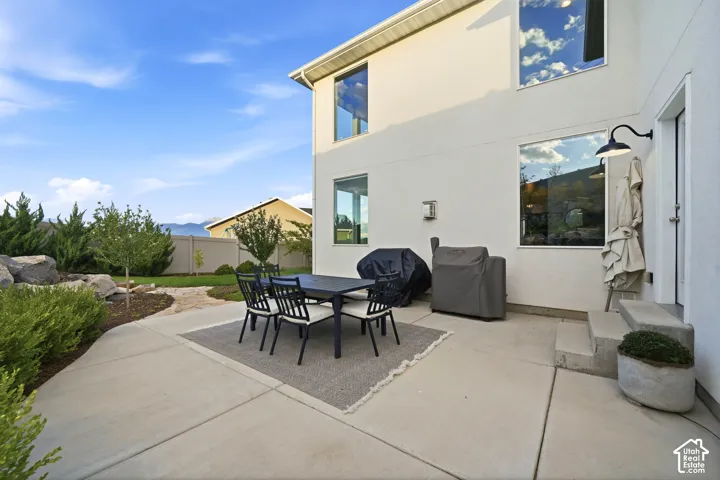 Expansive concrete patio with direct outdoor access and an exterior wall light