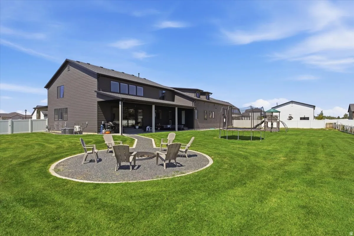 Expansive green lawn with a dedicated fire pit area
