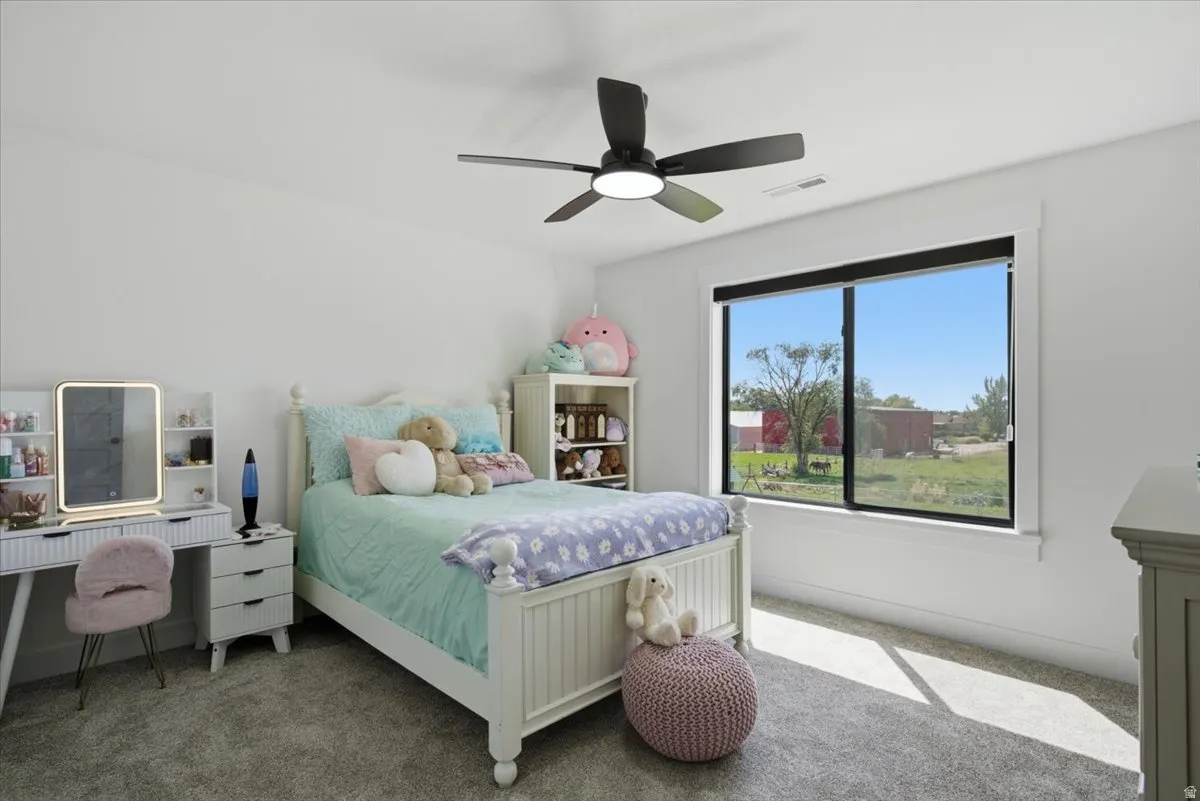Recessed lighting, ceiling fan with integrated light, large window with black trim, and wall-to-wall carpeting