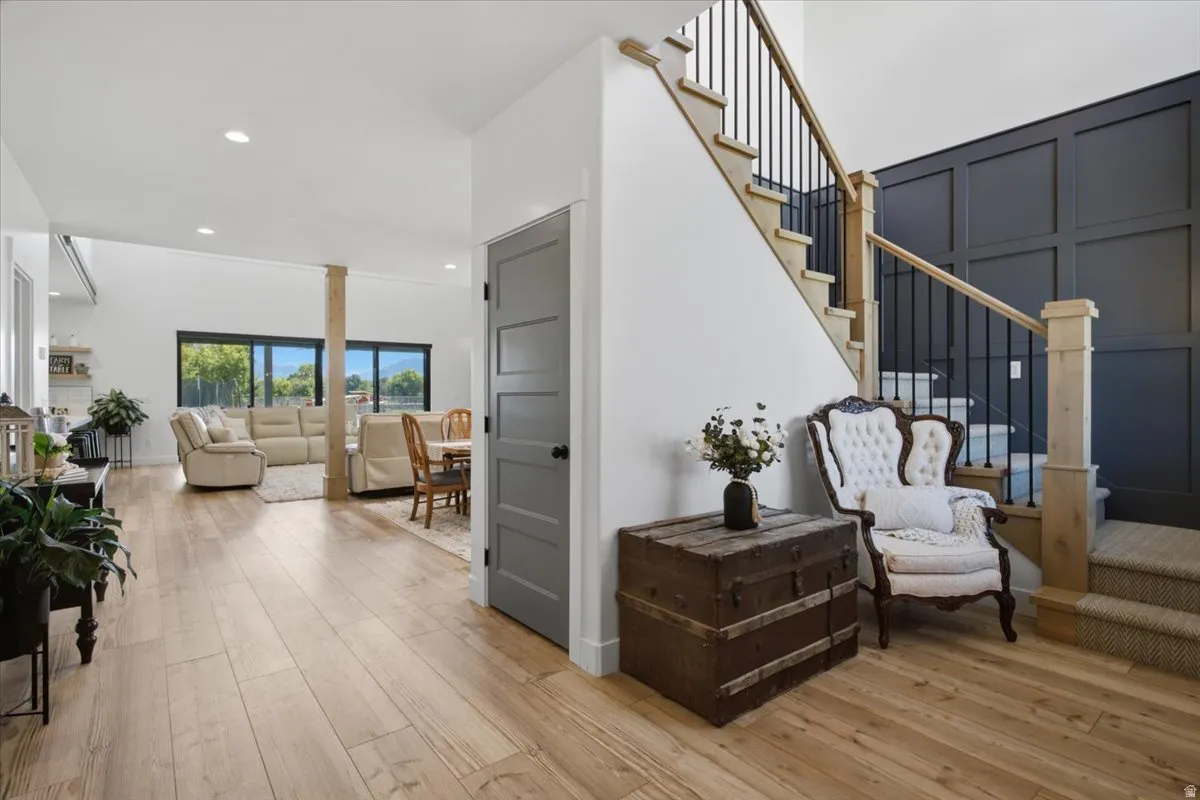 Wood-finish flooring throughout, with a carpeted staircase featuring black wrought iron balusters