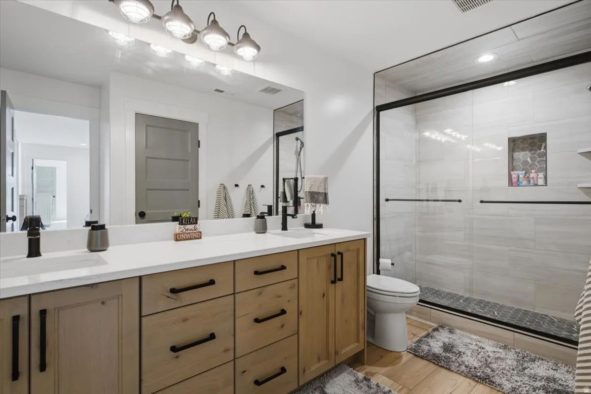 Dual vanity with light wood-finish cabinetry and black hardware