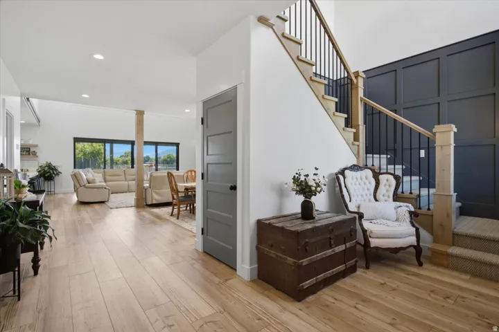 Wood-finish flooring throughout, with a carpeted staircase featuring black wrought iron balusters