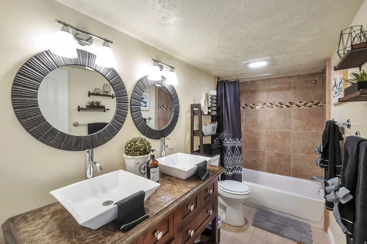 Dual vanity with vessel sinks, chrome fixtures, and wood-finish countertop