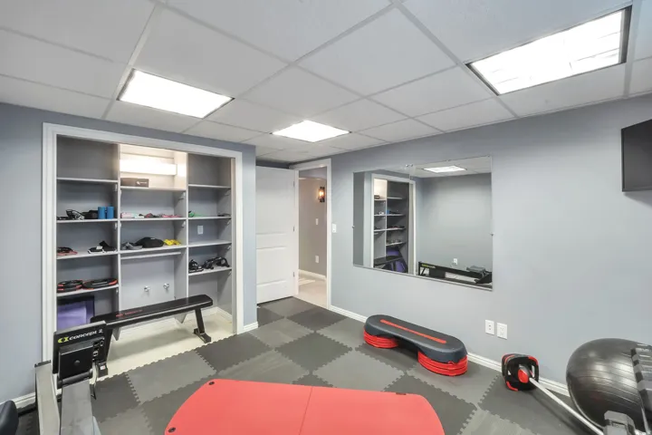 Built-in shelving, full-width wall mirror, and integrated ceiling lighting