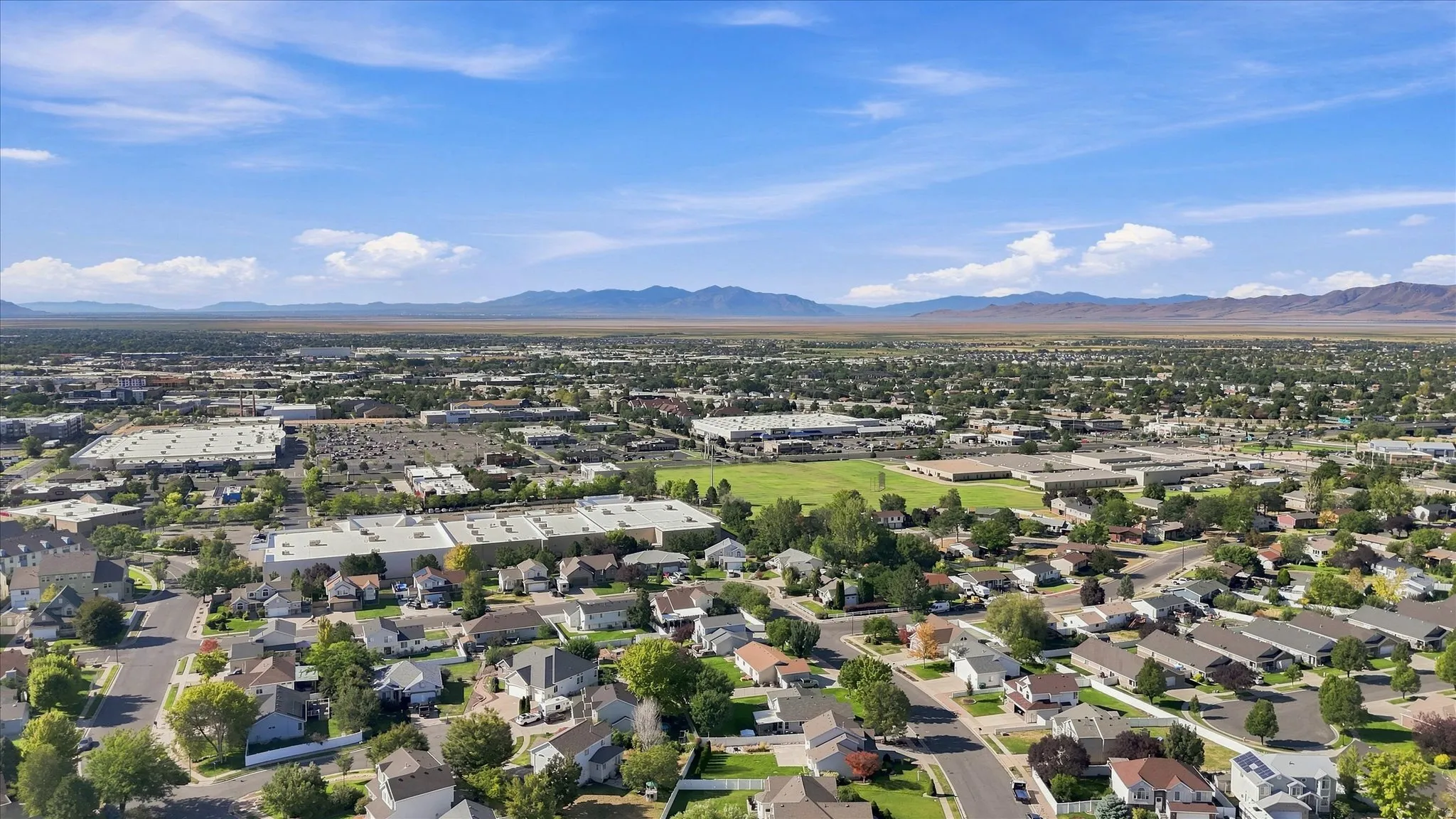 Expansive neighborhood setting with residential properties and distant mountain backdrop