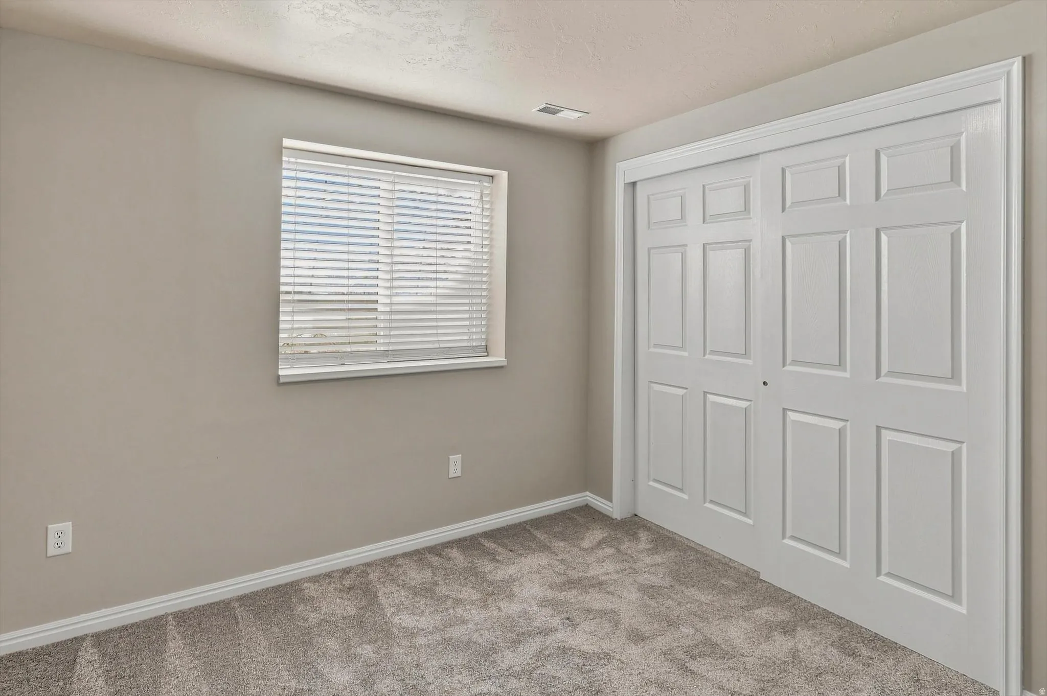 Neutral-toned walls complement the gray carpeting