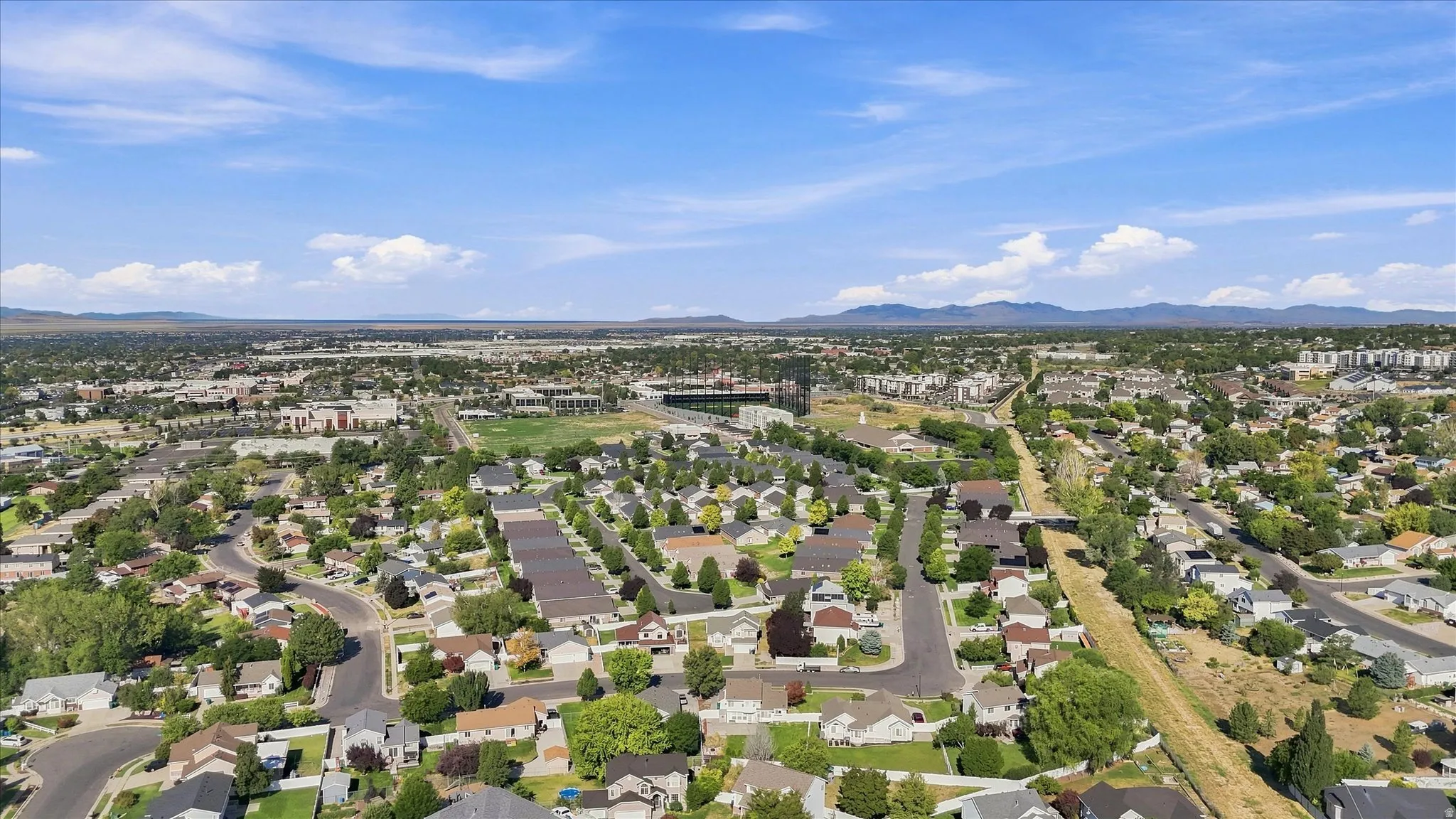 Expansive cityscape with residential areas, commercial structures, and a prominent stadium