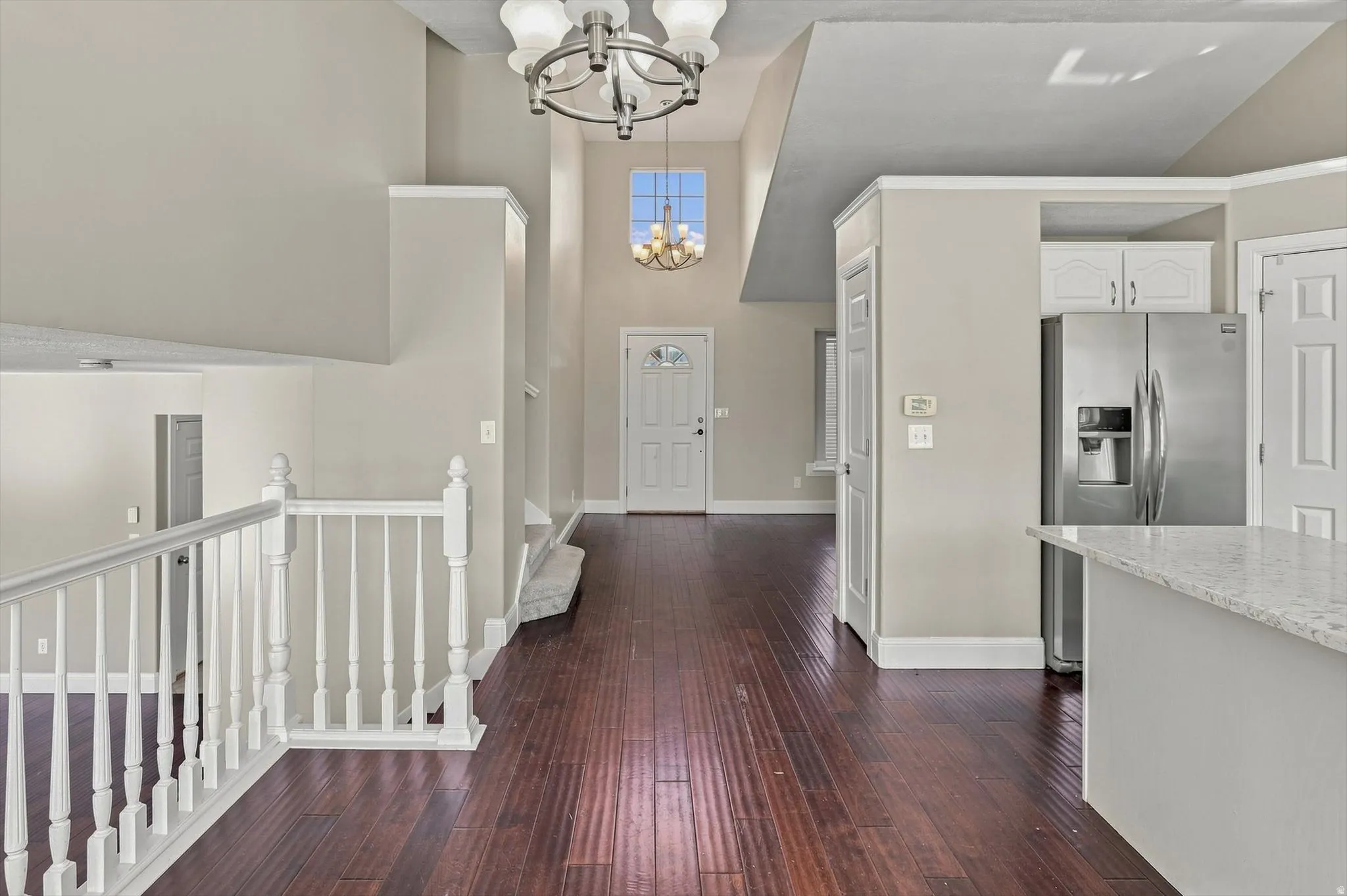 Expansive great room with soaring vaulted ceilings and dark wood-finish flooring