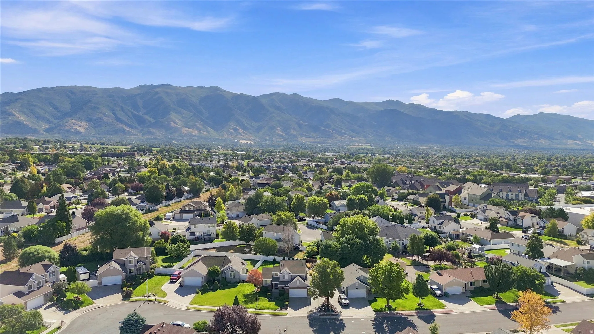 Mountain backdrop, residential area, mature trees, paved streets, single-family homes
