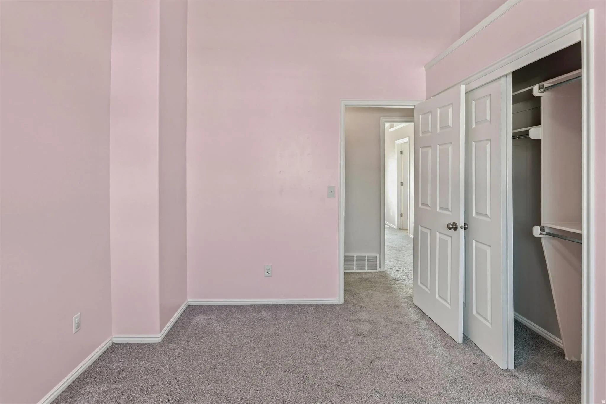 Soft pink walls complemented by grey carpet