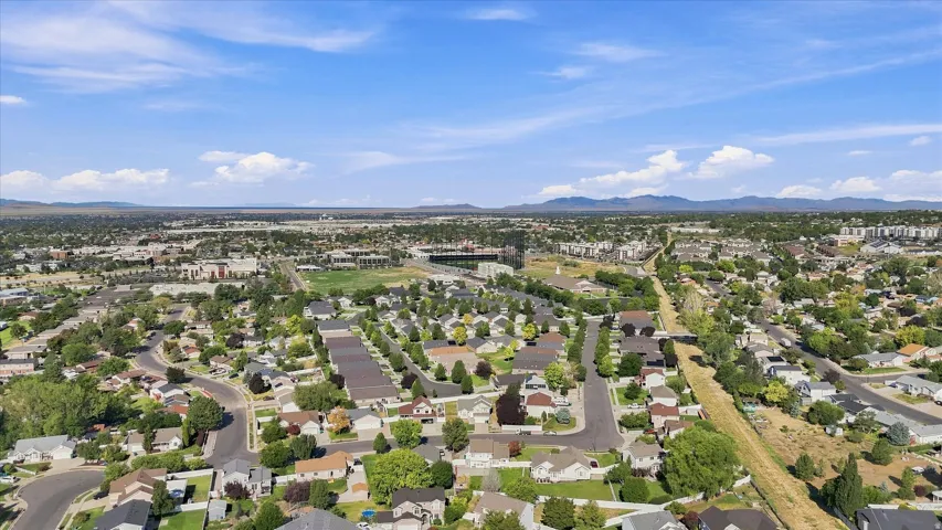 Expansive cityscape with residential areas, commercial structures, and a prominent stadium