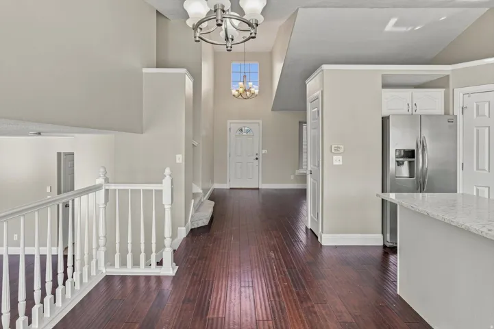 Expansive great room with soaring vaulted ceilings and dark wood-finish flooring
