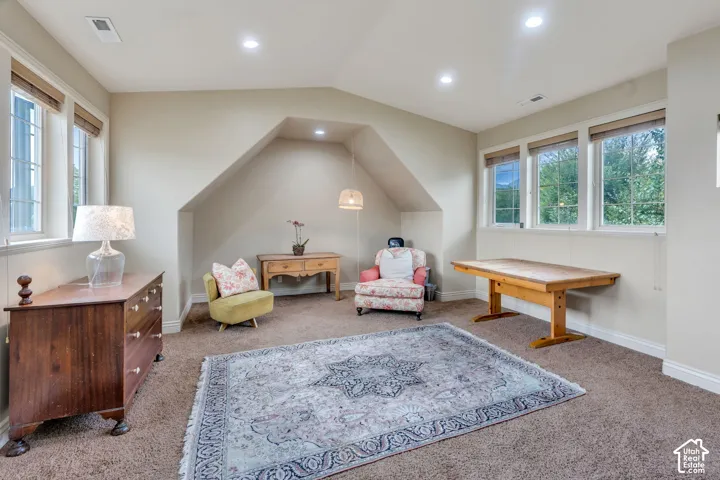 Recessed lighting, sloped ceiling detail, multiple windows, and light-toned wall finishes