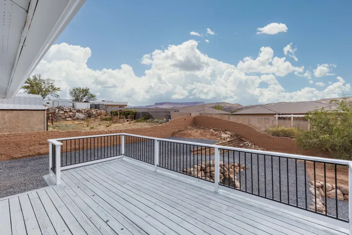 Spacious outdoor deck with a white painted surface and black metal railings