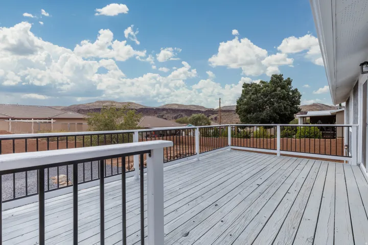 Expansive outdoor deck with painted wood flooring and metal railings