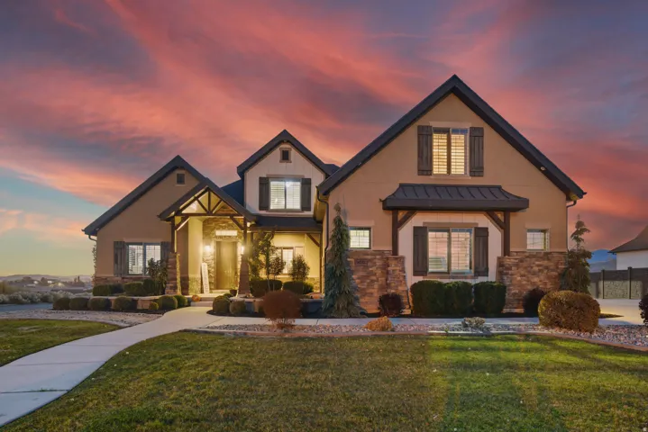 Craftsman-style exterior with stone veneer accents, stucco siding, and dark trim