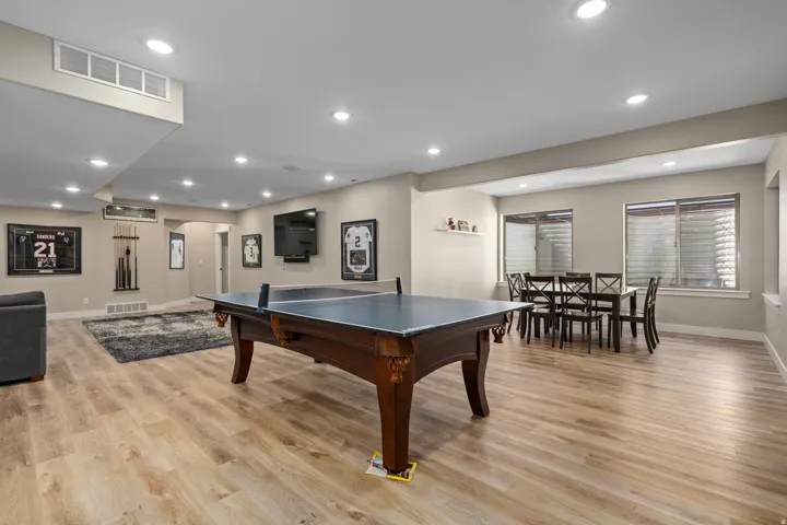 Expansive recreation space featuring recessed lighting, light wood-finish flooring, and multiple windows