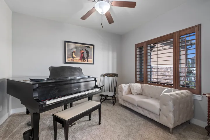 Recessed lighting, ceiling fan, wood-frame window shutters, and textured carpeting