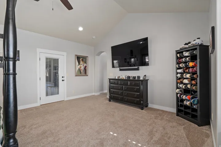 Carpeted room with vaulted ceilings and a glass-paneled door