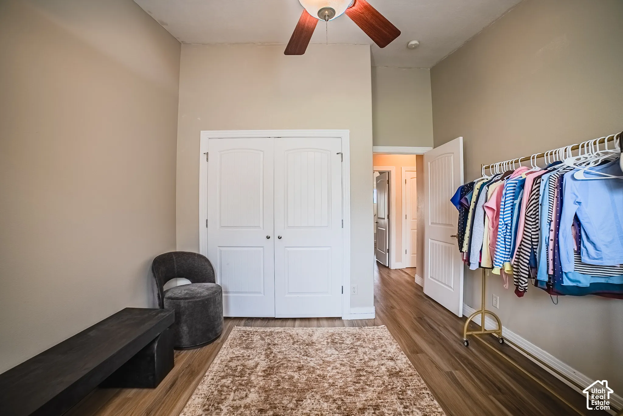 Vaulted ceiling with a ceiling fan, wood-finish flooring, and white double-door closet