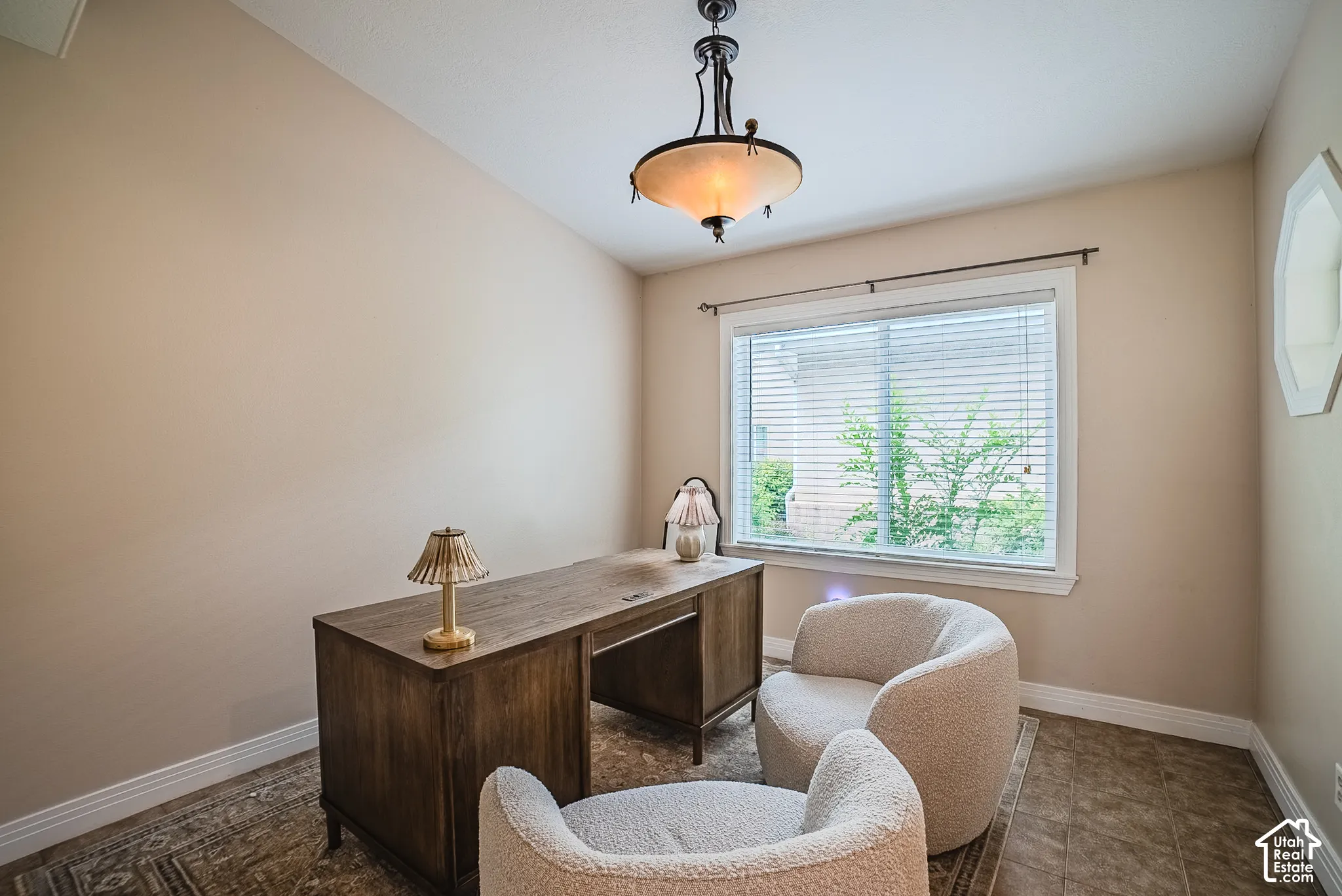 Room featuring a large window, decorative wall cutout, tray ceiling, and a ceiling-mounted light fixture