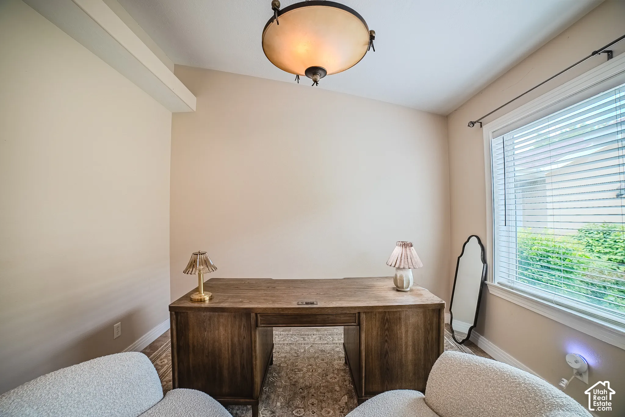 Vaulted ceiling with an overhead light fixture, wood-finish flooring, and a large window with blinds