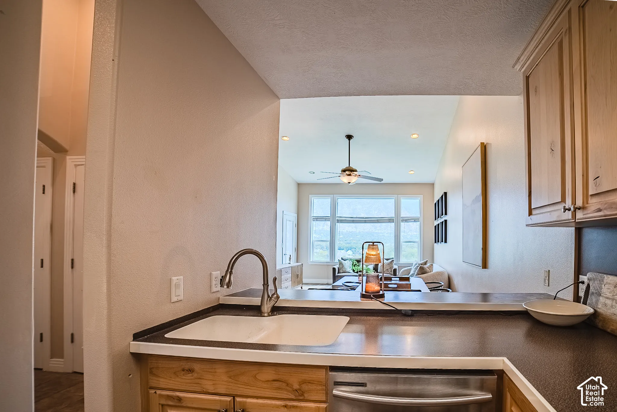 Kitchen featuring a stainless steel dishwasher, undermount sink, and wood-finish cabinetry