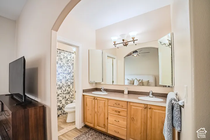 Dual vanity with wood-finish cabinetry, integrated sinks, and a framed mirror
