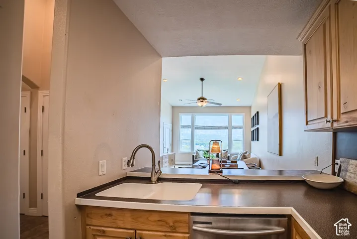 Kitchen featuring a stainless steel dishwasher, undermount sink, and wood-finish cabinetry