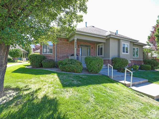 Brick and stucco exterior with mature landscaping and manicured lawn