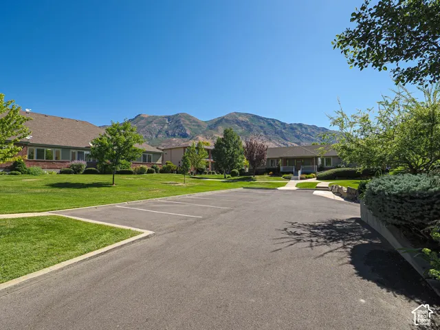 Sprawling circular driveway with mature landscaping, manicured lawn, and established trees framing the property