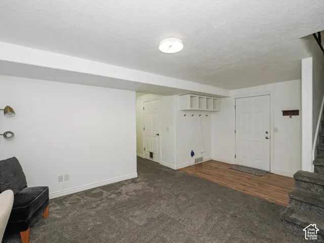 Interior entry space featuring wood-finish flooring, built-in storage cubbies with integrated wall hooks, and a multi-panel exterior door