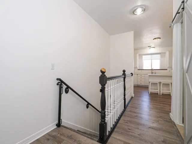 Wood-finish flooring throughout, white walls, and recessed lighting