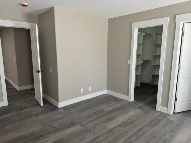 Spacious Primary Bedroom with wood-finish flooring and neutral wall tones