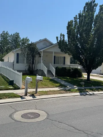 Vinyl-sided exterior with a covered porch featuring white railing and steps