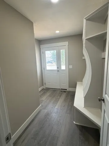Entryway featuring wood-finish flooring, recessed lighting, double entry doors, a built-in bench, and built-in shelving