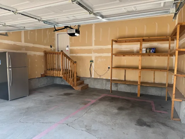 Concrete flooring, wood staircase, built-in shelving, new overhead garage door system, interior access door