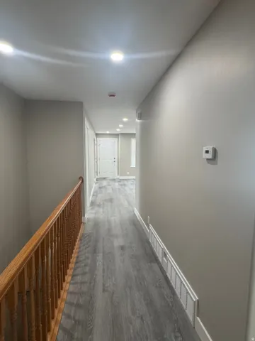 Recessed ceiling lighting, wood-finish flooring, light neutral wall paint, and white trim accents