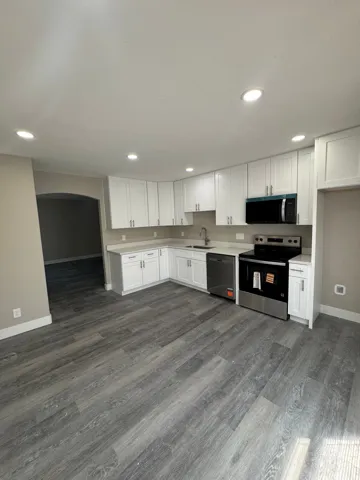 Updated kitchen with white cabinetry and stainless steel appliances