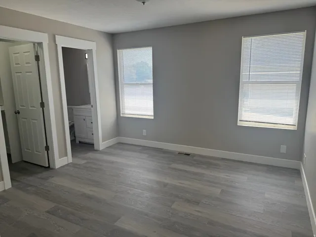 Primary Bedroom Light gray walls with wood-finish LVP flooring