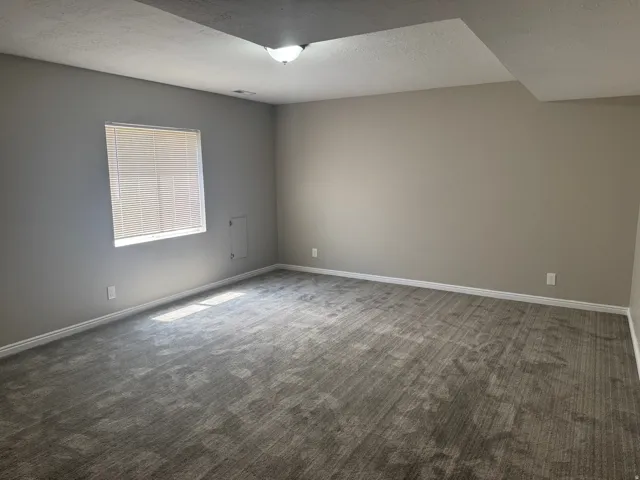 Neutral wall tones, gray patterned carpet, and recessed lighting