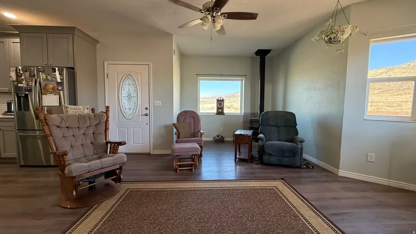 Wood-finish flooring throughout, ceiling fan, and a wood-burning stove