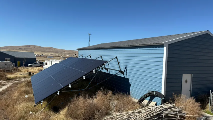 Metal-sided building with a dark metal roof, featuring a white access door