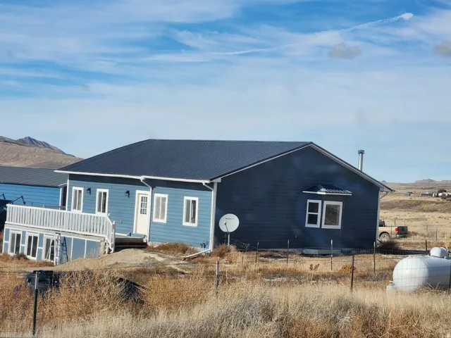 Blue siding exterior with a dark roof and white trim