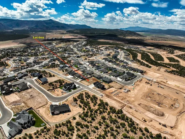 Aerial overview of a residential development with established homes, new construction, and undeveloped lots