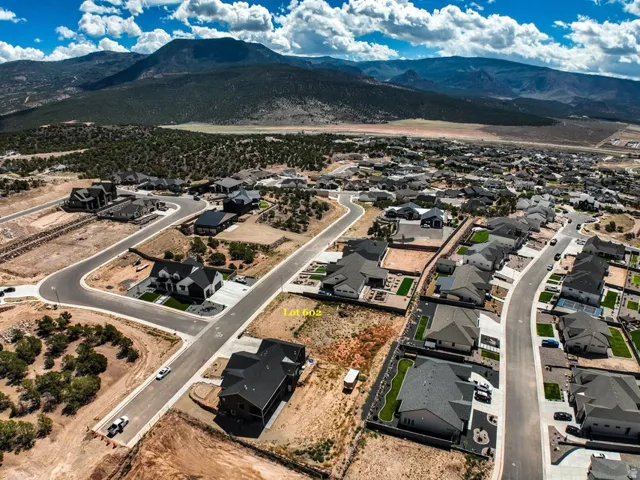 Mountain backdrop, residential development, paved roads, established homes, undeveloped lot