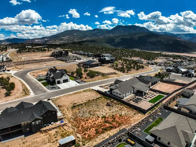 Expansive residential development with mountain backdrop, paved roadways, and landscaped properties