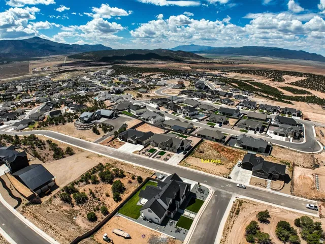 Expansive desert landscape with mountain backdrops, paved roads, and scattered residential properties