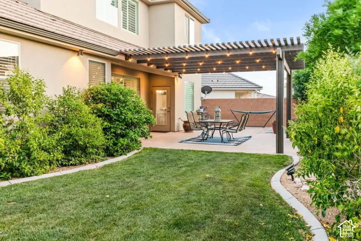 Backyard: Lawn and mature shrubs leading back to the pergola
